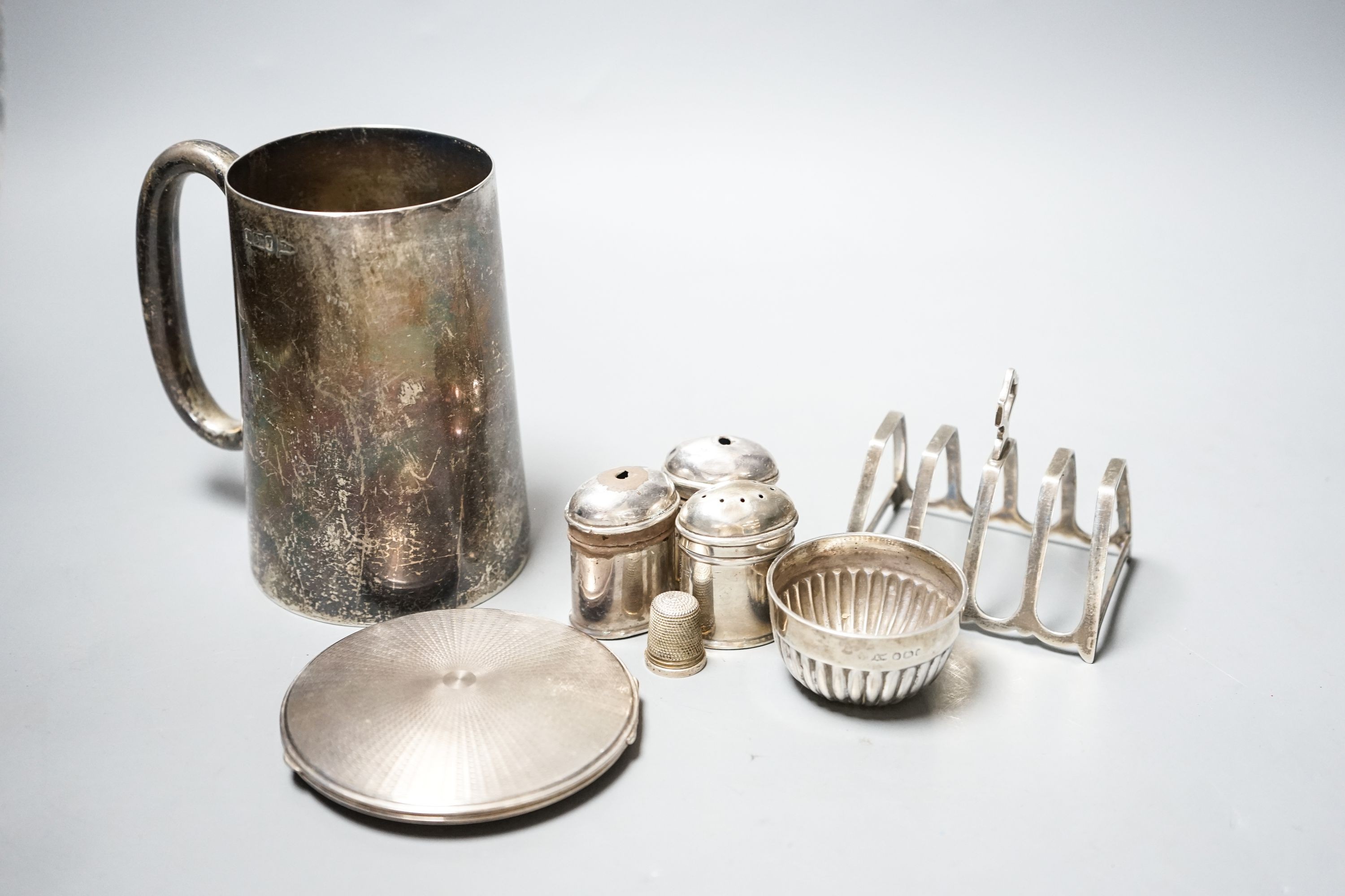 An Edwardian silver mug, by Walker & Hall, Sheffield, 1901, 12.4 cm, a silver toastrack, silver compact, four silver condiments(a.f.), a silver bowl and silver thimble